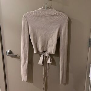 Open-back ribbed tan mock neck sweater